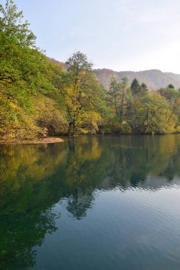 Kuzey Kafkasya 'nın dağlarındaki Cherek Vadisi' nde sonbaharda mavi göl manzarası                               