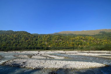  Kuzey Kafkasya 'nın dağlarındaki Cherek Vadisi' nde taşları ve dağları olan bir dağ nehri manzarası                              
