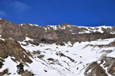 Karlı dağ sırasının ve mavi gökyüzünün manzarası Kuzey Kafkasya 'nın dağlarındaki Azau Vadisi' nde Elbrus Dağı 'nın eteklerinde çığ tuzakları var.                               
