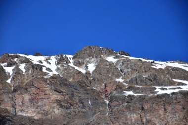 Kuzey Kafkasya dağlarındaki Azau Vadisi 'ndeki Elbrus Dağı' nın eteklerindeki karlı dağ sırasının ve mavi gökyüzünün görüntüsü.                              