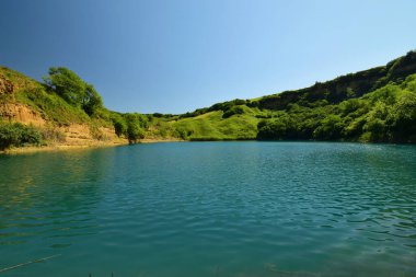 Kuzey Kafkasya dağlarındaki Kabardino-Balkaria 'nın Zolsk bölgesindeki yeşil bitki örtüsüyle çevrili güzel Alp Karst Gölü Panoraması                              