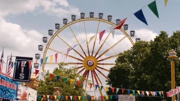 Riesenrad Dreht Sich Mit Bunten Fahnen Vordergrund — Stockvideo