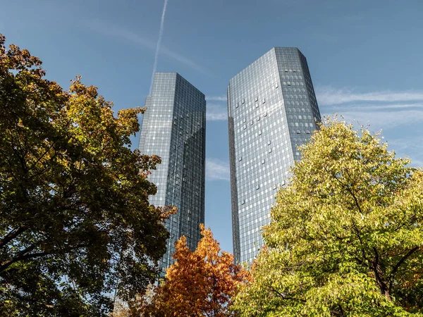 Deutsche Bank Skyscraper low angle on a sunny day with trees in forefront, frankfurt, hessen, germany