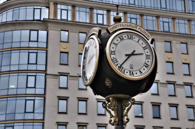 Modern bir binanın arka planında klasik şehir saati