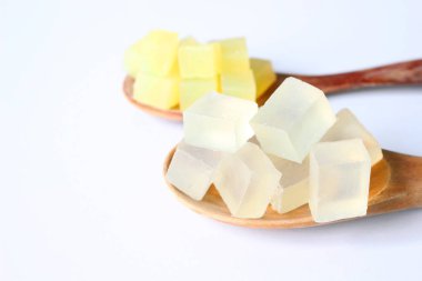 Kadar yakın, şeffaf dilimlenmiş ve beyaz zemin üzerine sarı Koza gliserin sabun temelleri.