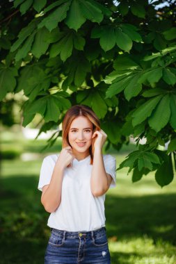 Yeşil park gülümseyen güzel genç kadın portresi.