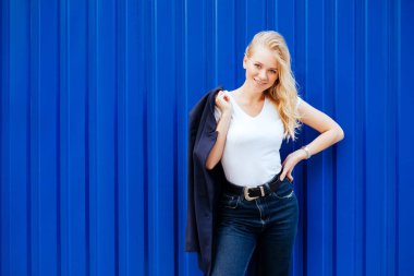 Şehrin sokak üzerinde mavi zemin üzerine mavi ceketli genç kız