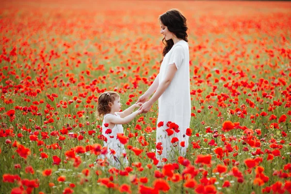 Güzel anne ve kızı bahar çiçek alanında oynama