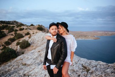 Dağlarda romantik yaz aşk hikayesi bir günbatımı üzerinde. Genç kız ve erkek aşık.