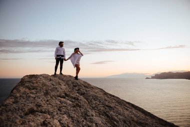Dağlarda romantik yaz aşk hikayesi bir günbatımı üzerinde. Genç kız ve erkek aşık.