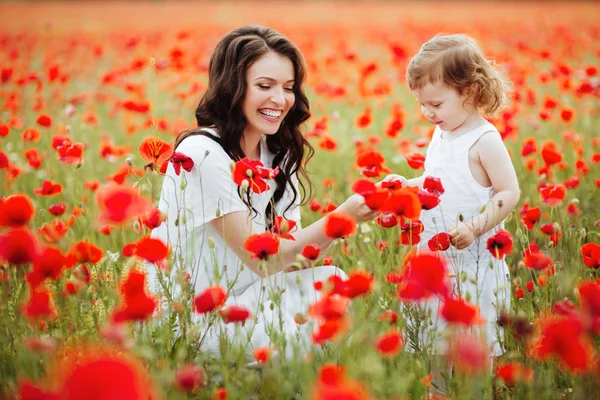 Güzel anne ve kızı bahar çiçek alanında oynama