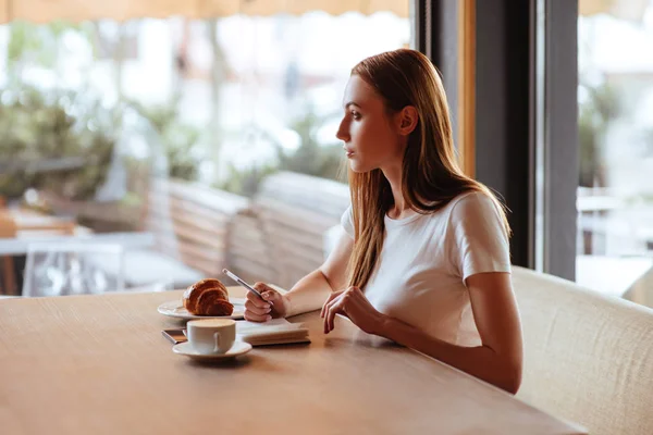 Hermosa Chica Cafetería Con Sabrosa Escritura Capuchino Cuaderno Blanco — Foto de Stock