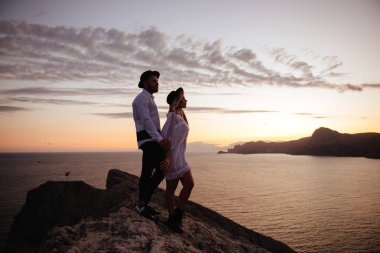 Dağlarda romantik yaz aşk hikayesi bir günbatımı üzerinde. Genç kız ve erkek aşık.