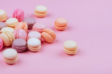 Macaroons pembe bir arka plan üzerinde farklı türleri. Tatlı ve renkli Fransızca macaroons.