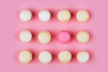 Pembe bir arka plan üzerinde üstten görünüm renkli macaron veya acıbadem kurabiyesi. seçici odak. Düz yatıyordu