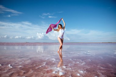 Zarif kadın pembe su üzerinde dans. Günbatımı ve yapısı.