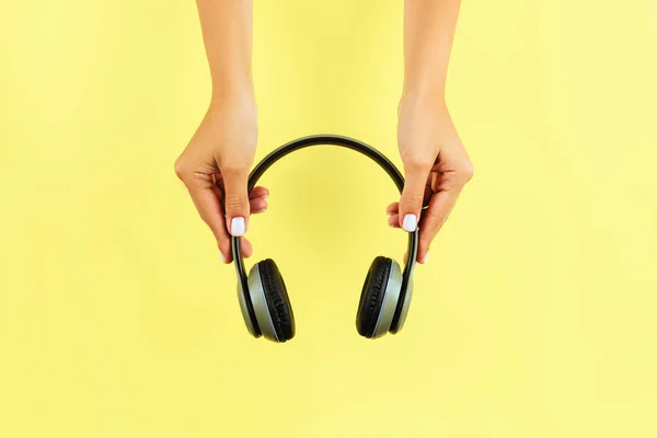 Female Hands Holding Headphones Yellow Background — Stock Photo, Image