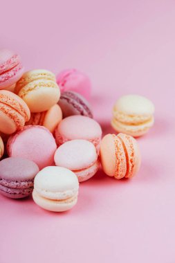Tatlı macaroons vintage pastel renkli sesi üzerine pembe bir arka plan ile. Boşaltmak.