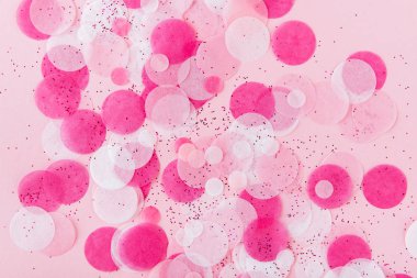 Flatlay ve renkli yuvarlak kağıt konfeti pembe kağıt üzerinde. Üstten görünüm