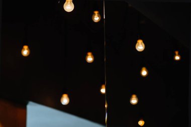 Ampul yanar arka plan üzerinde zayıf yanan sarı ışık bulanık