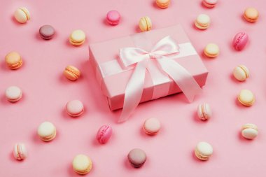 Hediye kutusu ve macarons yazmak için kopya alanı ile pembe arka plan üzerinde.