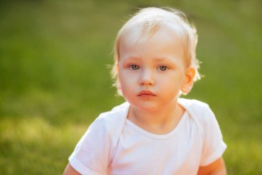 Komik sarışın yürümeye başlayan çocuk yaz bahçesinde. Rahat yaşam tarzı fotoğraf.