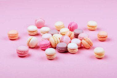 Macaroons pembe bir arka plan üzerinde farklı türleri. Tatlı ve renkli Fransızca macaroons.