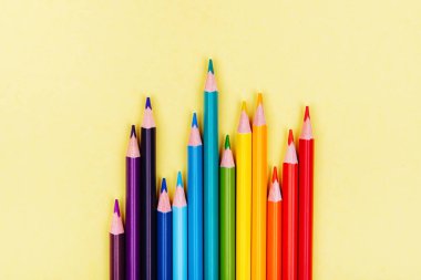 Üst üste sarı arka plan üzerinde renkli kalemler. Eğitim, okul kavramı. Kesintisiz renkli pensils yakın çekim.