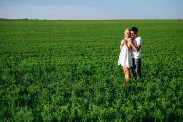 The lovely beautiful couple in the field. Romantic love story in the park. Young girl and boy in love.