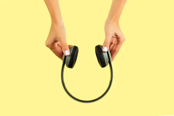 Female Hands Holding Headphones Yellow Background — Stock Photo, Image