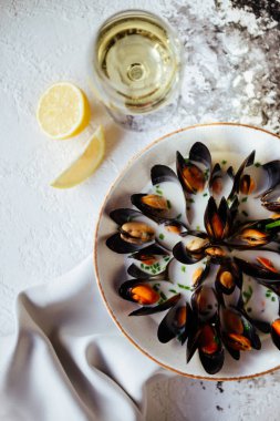 Kaynamış midye ve beyaz şarap beyaz taş masada. Üst görünüm.