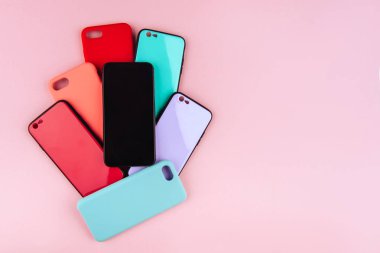 Beyaz bir arka plan üzerinde izole smartphone için renkli plastik kümesini kapsayan