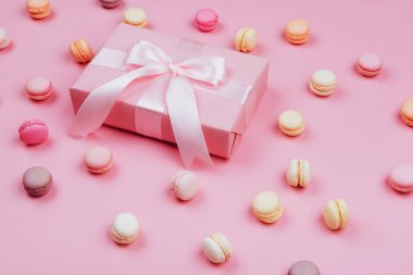 Hediye kutusu ve macarons yazmak için kopya alanı ile pembe arka plan üzerinde.