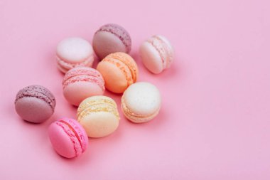 Macaroons pembe bir arka plan üzerinde farklı türleri.