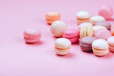 Macaroons pembe bir arka plan üzerinde farklı türleri. Tatlı ve renkli Fransızca macaroons.