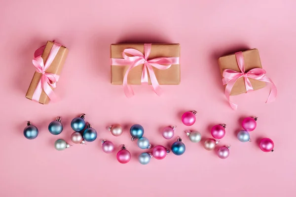 Різдвяна Рамка Подарунковими Коробками Кульками Прикрасами Блискітками Рожевому Столі Зверху — стокове фото