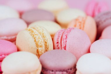 Macaroons pembe bir arka plan üzerinde farklı türleri. Tatlı ve renkli Fransızca macaroons.