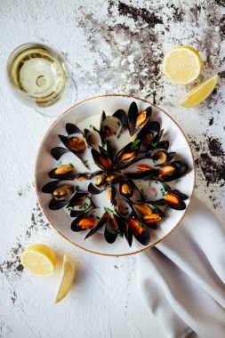 Kaynamış midye ve beyaz şarap beyaz taş masada. Üst görünüm.