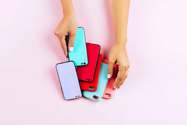 Ruce Držící Barevné Smartphone Případy Růžový Pozadí — Stock fotografie