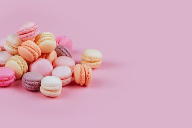 Tatlı pembe bir arka plan üzerinde renkli macarons Fransız.