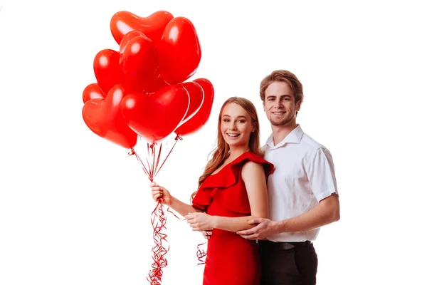 Besos pareja posando sobre fondo blanco con globos corazón . — Foto de Stock