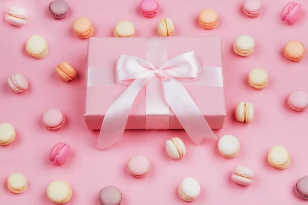 Gift box and macarons on pink background — Stock Photo, Image