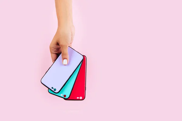 Händer som håller färgglada Smartphonefodral — Stockfoto