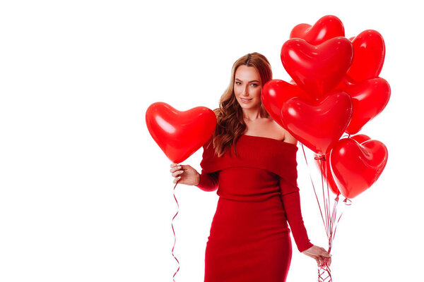 Attractive young girl in red dress holding Valentines Day helium balloon