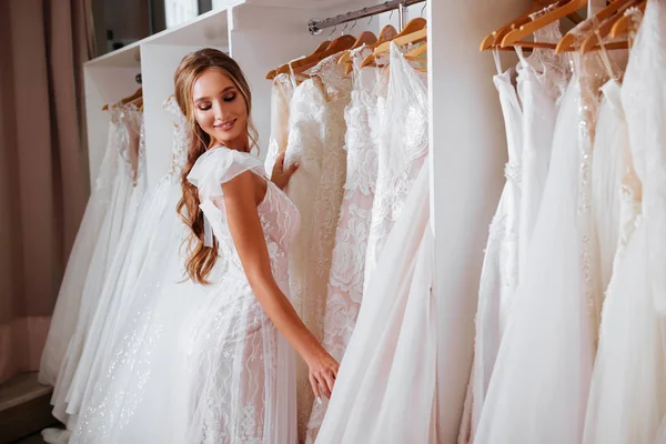 Zadní pohled na mladé ženy ve svatebních šatech při pohledu na svatební šaty — Stock fotografie