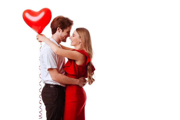 Besos pareja posando sobre fondo blanco con globos corazón . — Foto de Stock