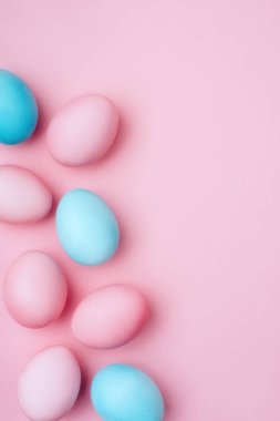 Pembe bir arka plan üzerinde renkli Paskalya yumurtaları.