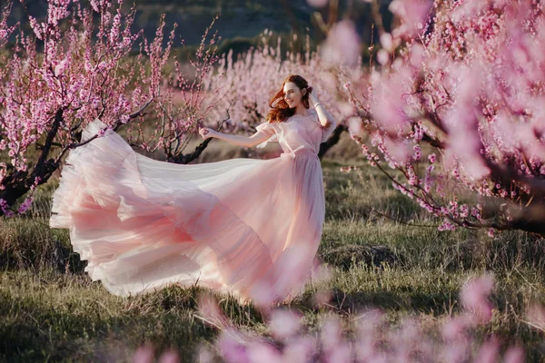 Belle jeune fille sous l'arbre rose fleuri — Photo