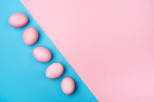 Colored Easter eggs on a pink background.