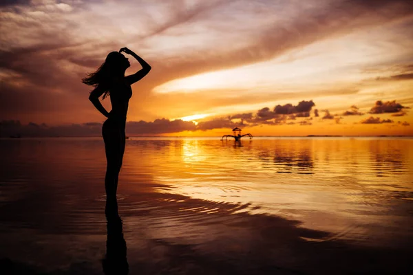 夕暮れの浜辺を歩く女性. — ストック写真